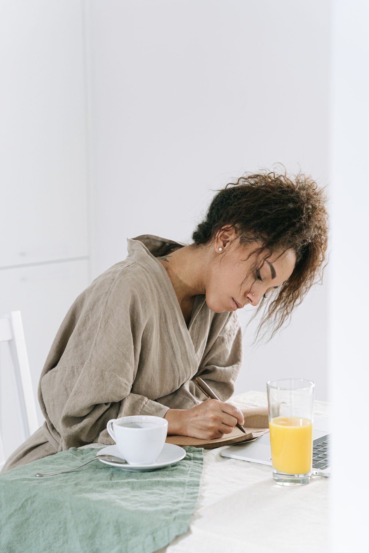 A person writing at a breakfast table
