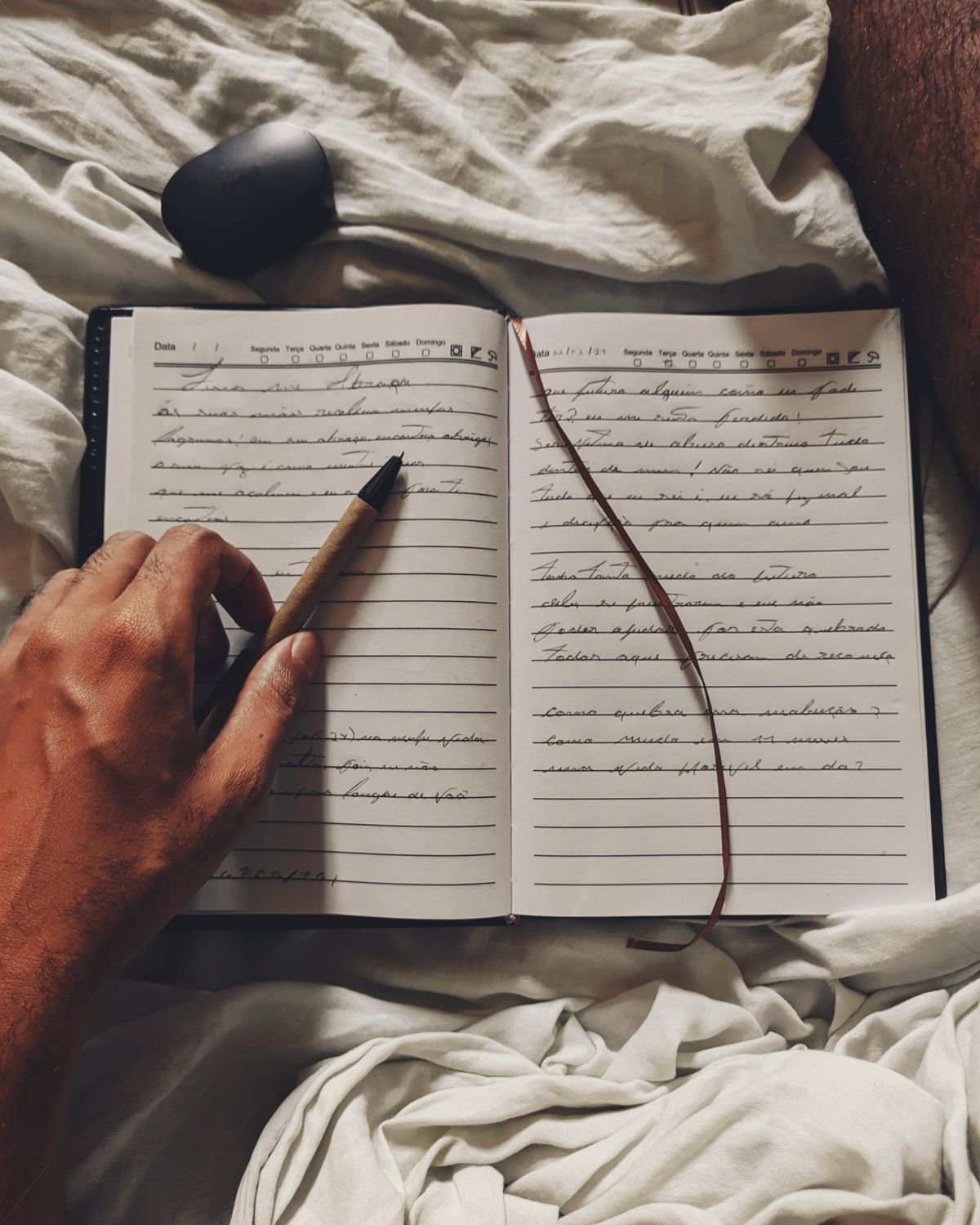 A hand writing in an open notebook
